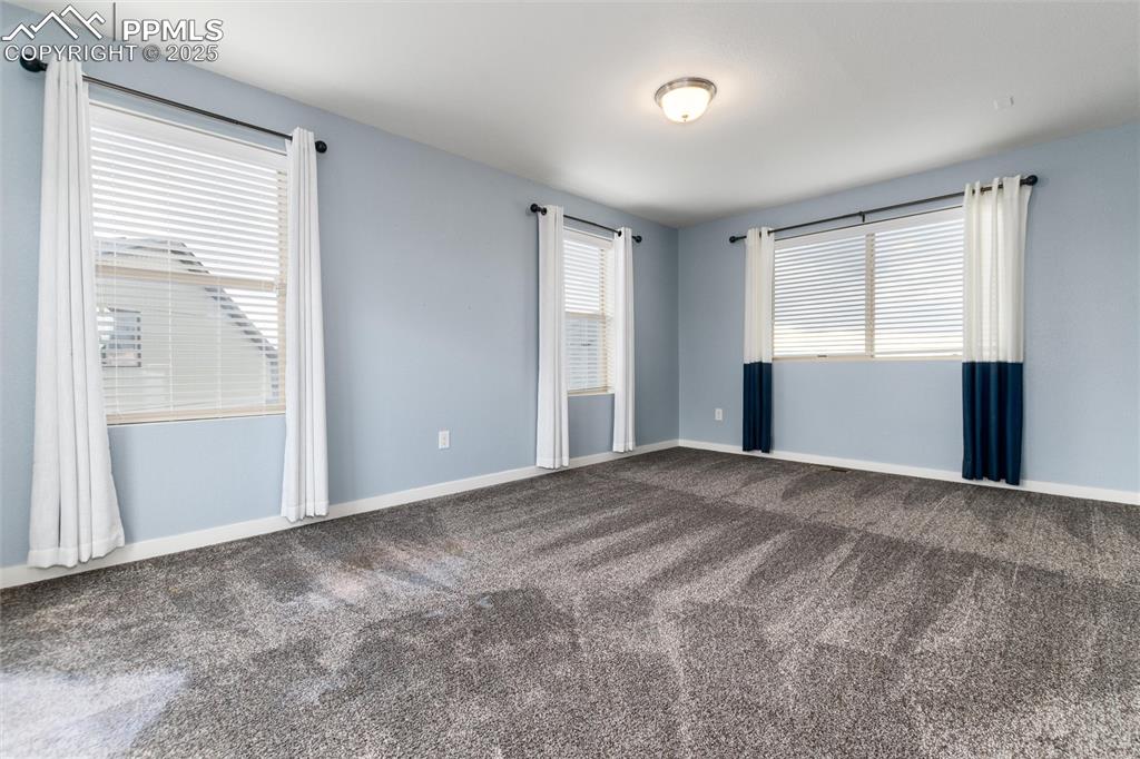 Image 26 of 33: Empty room featuring dark carpet and baseboards