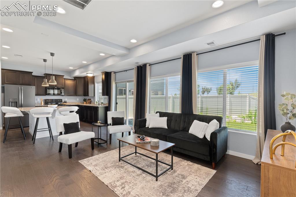 Image 5 of 33: Living room featuring dark wood-style floors and recessed lighting