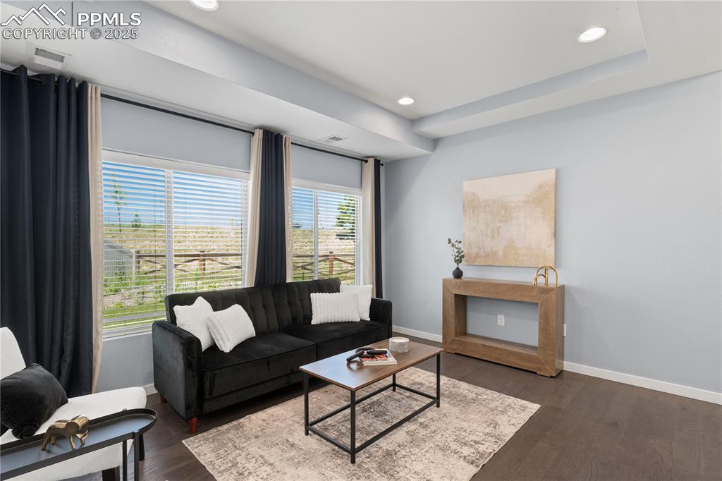 Image 6 of 33: Living area with dark wood-style flooring and recessed lighting