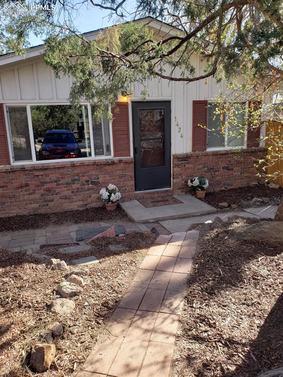 Image 7 of 7: Entrance to property featuring brick siding and board and batten siding