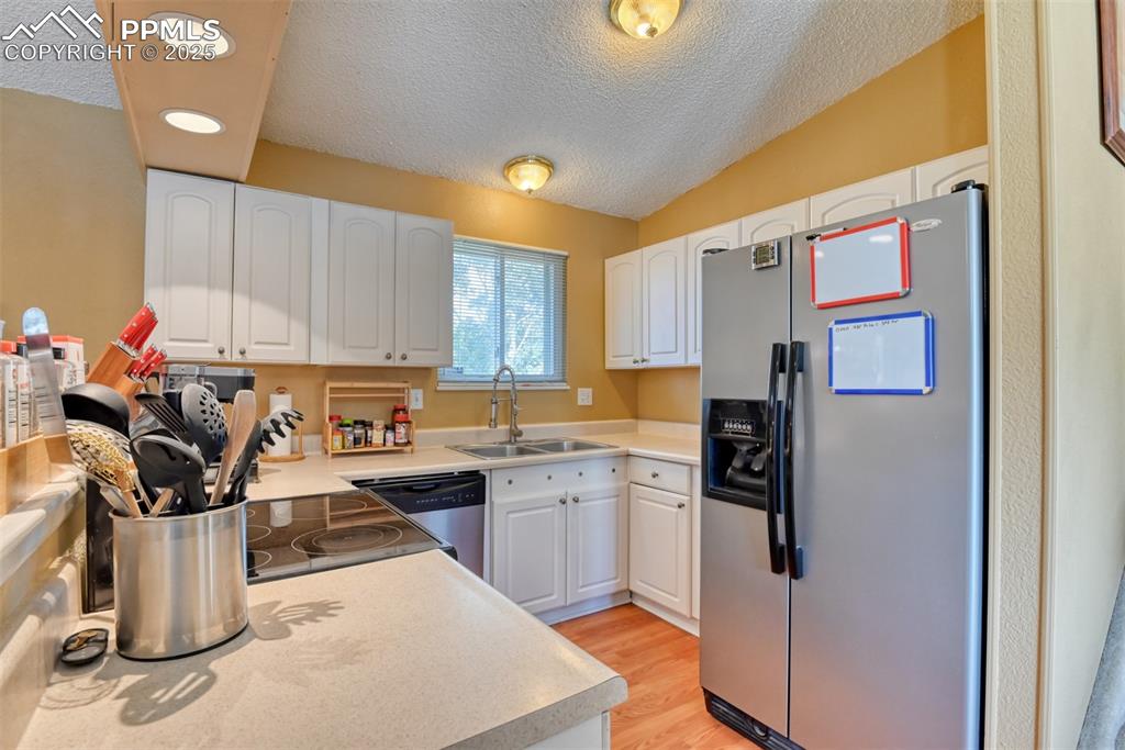 Image 10 of 38: Kitchen featuring appliances with stainless steel finishes, light counterto