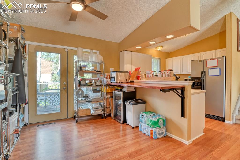 Image 13 of 38: Breakfast area with light countertops, white cabinets, stainless steel frid
