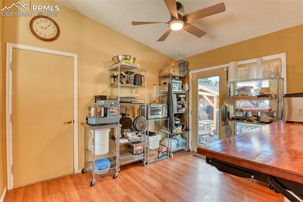 Image 14 of 38: Breakfast area with light wood-style flooring, a ceiling fan, and vaulted c