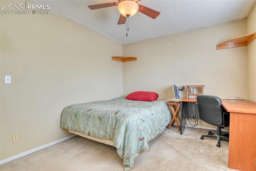 Image 22 of 38: Bedroom with carpet flooring, a textured ceiling, a desk, and a ceiling fan