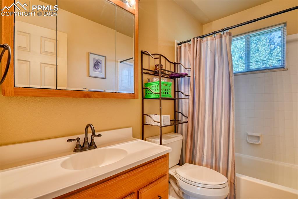 Image 24 of 38: Bathroom with shower / tub combo and vanity