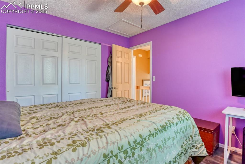 Image 26 of 38: Bedroom featuring a textured ceiling, attic access, dark wood-type flooring