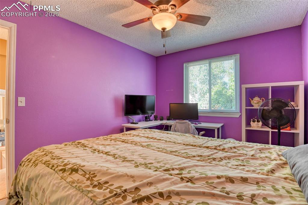 Image 27 of 38: Bedroom with ceiling fan and a textured ceiling