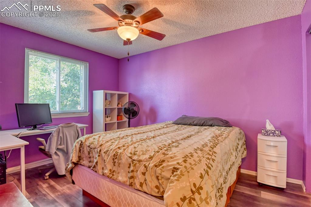 Image 28 of 38: Bedroom featuring dark wood-style flooring, a textured ceiling, a ceiling f