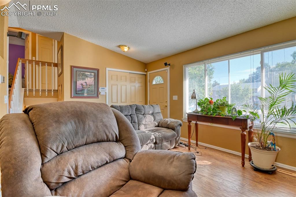 Image 3 of 38: Main Level Living room featuring wood finished floors, vaulted ceiling, and