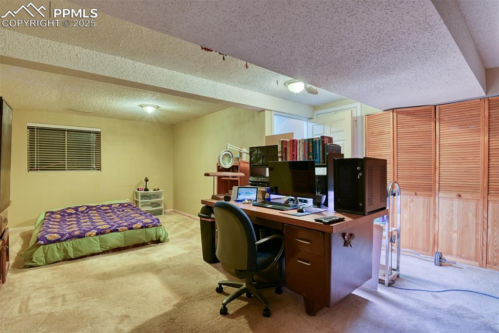 Image 31 of 38: Large bedroom in basement with a textured ceiling and carpet floors