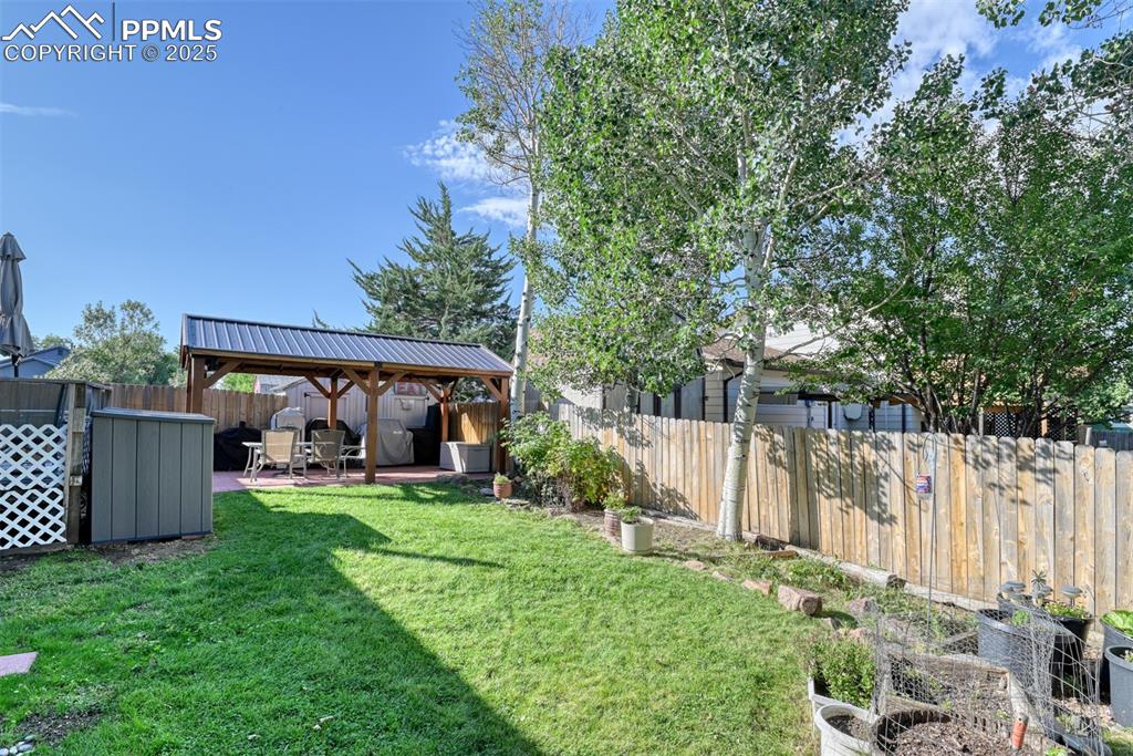 Image 34 of 38: Fenced backyard featuring a patio and a gazebo