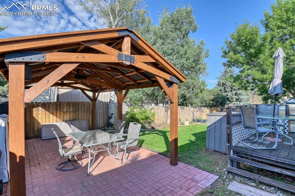 Image 35 of 38: Fenced backyard featuring outdoor dining space, a patio area, and a gazebo