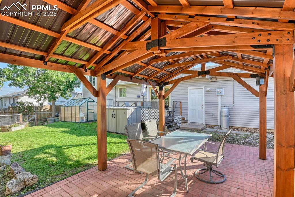 Image 36 of 38: Fenced backyard featuring an outbuilding, a patio area, outdoor dining spac