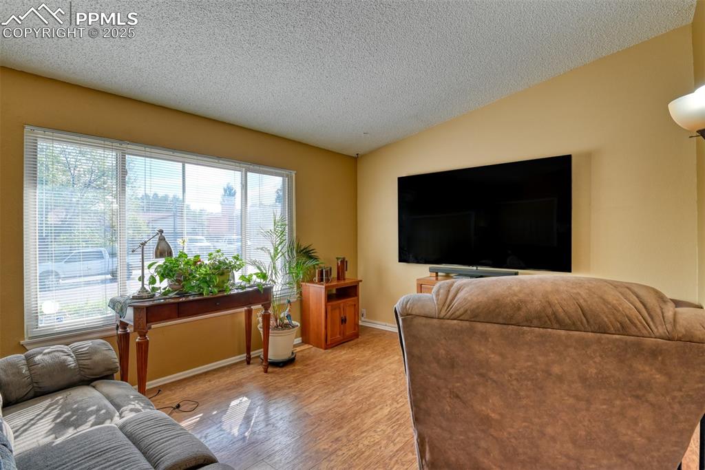 Image 5 of 38: Main Level Living room featuring a textured ceiling, wood finished floors, 