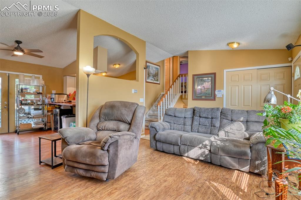 Image 6 of 38: Main Level Living room featuring vaulted ceiling, wood finished floors, sta