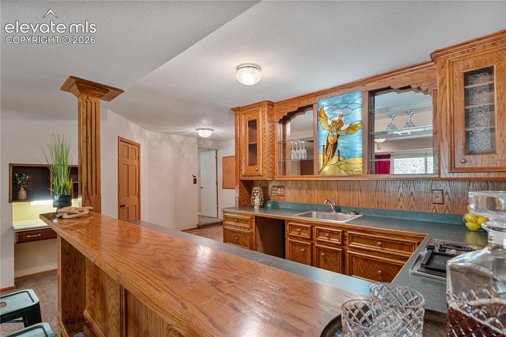 Image 22 of 49: Fantastic woodwork in the lower level Bar...tons of Cabinets, space for the