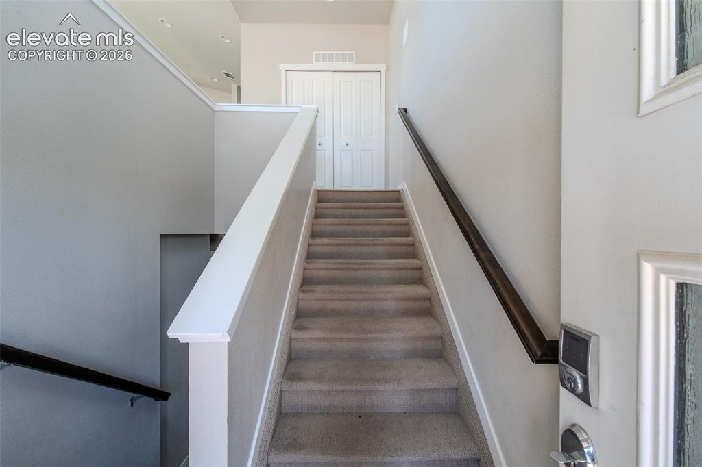 Image 10 of 46: Carpeted stairs to the upper level.