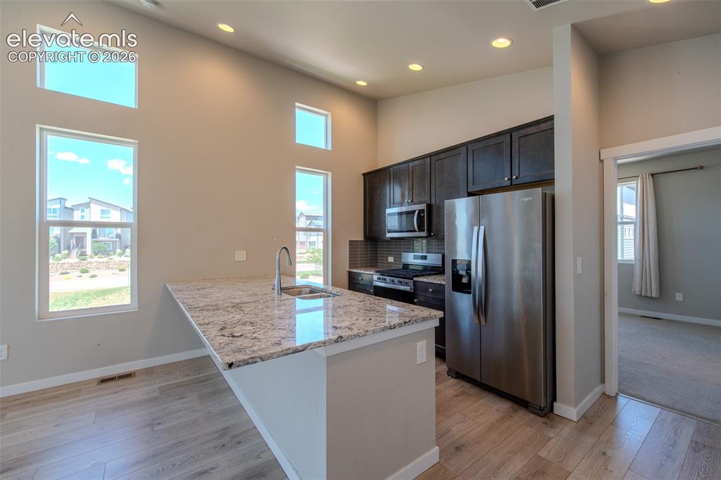 Image 18 of 46: Beautiful Kitchen with granite breakfast bar, espresso cabinets, and stainl