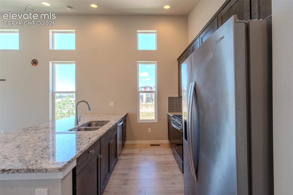 Image 19 of 46: The Kitchen boasts a dual stainless steel sink, dishwasher, gas range oven,