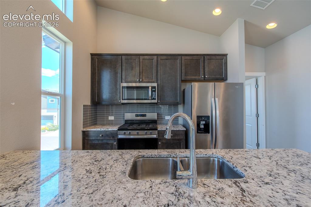 Image 22 of 46: Granite breakfast bar with double stainless steel sink.