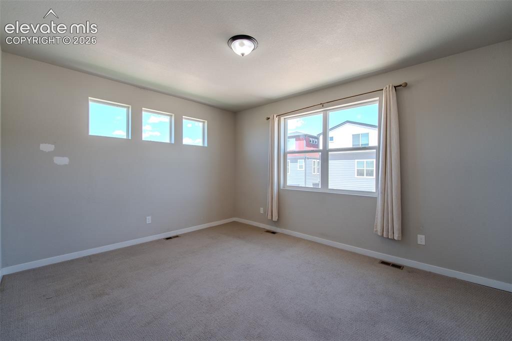 Image 23 of 46: Upper Level Primary Bedroom with neutral carpet.