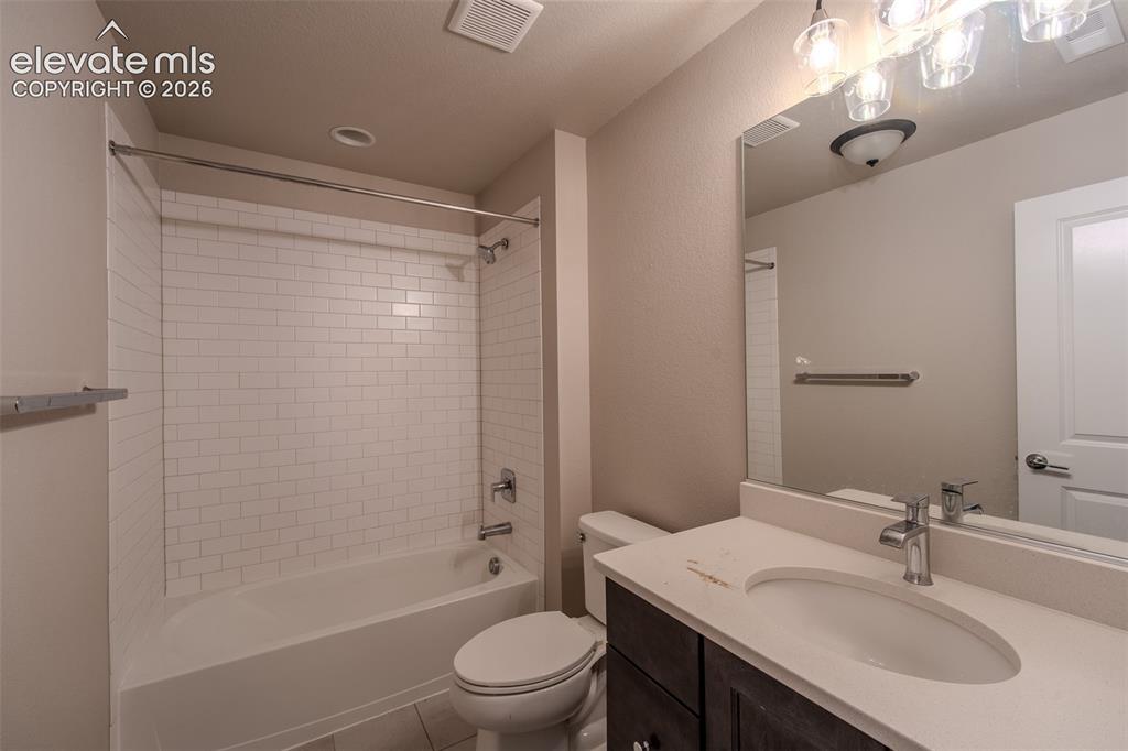 Image 37 of 46: Lower Level Full Bathroom with vanity, mirror, and tiled tub/shower.