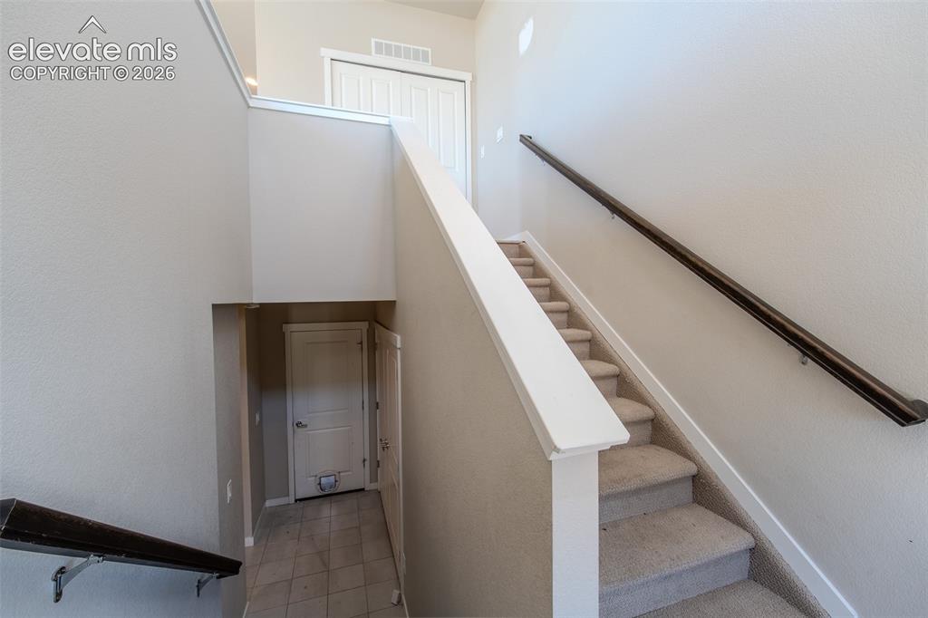 Image 9 of 46: Lower Level tiled front entry with stairs to the upper level.