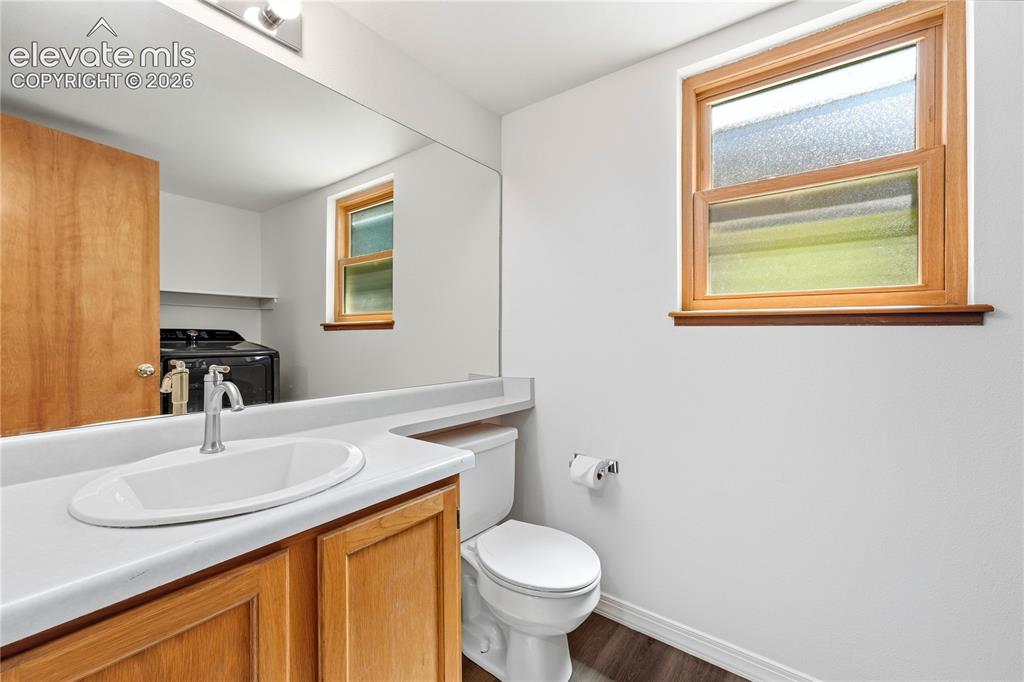 Image 13 of 47: Main level half bath with a full-width mirror