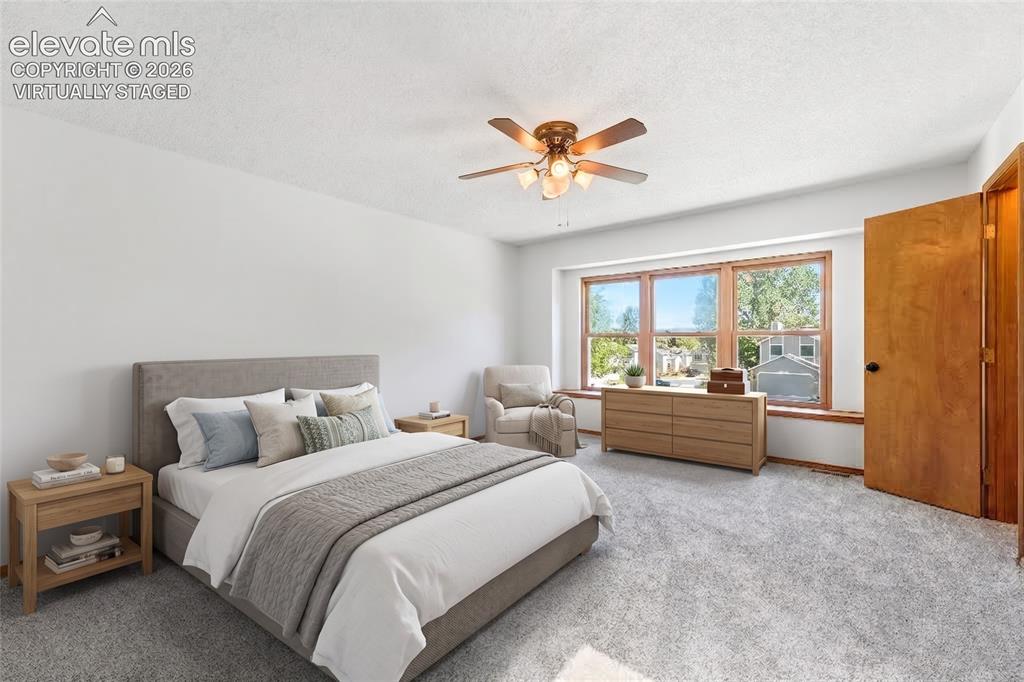 Image 15 of 47: Spacious room featuring light gray carpeting, a wide window with faux wood 