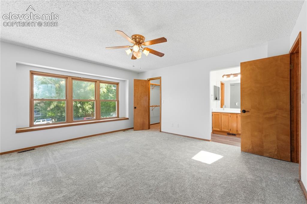 Image 17 of 47: Spacious room featuring light gray carpeting, a wide window with faux wood