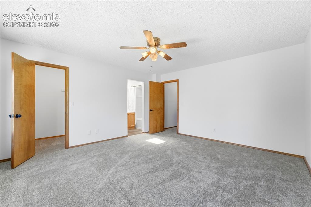 Image 18 of 47: Spacious room featuring light gray carpeting, and a ceiling fan with lighti
