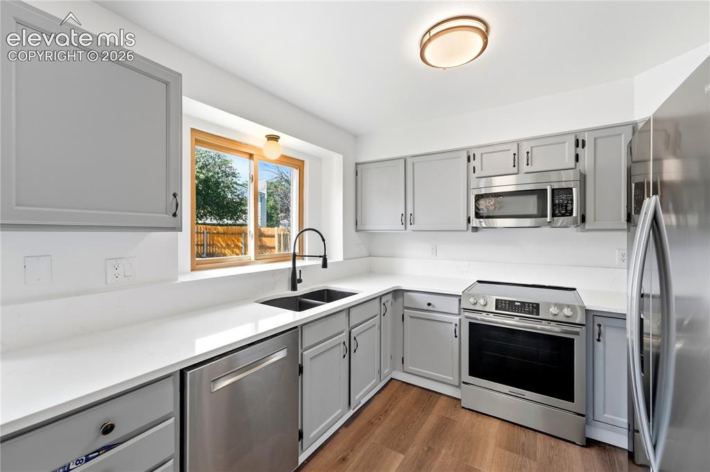 Image 2 of 47: Kitchen featuring gray cabinetry, stone quartz countertops, stainless steel