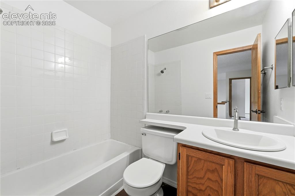 Image 24 of 47: White subway tile surround, built-in bathtub, and full-width mirror