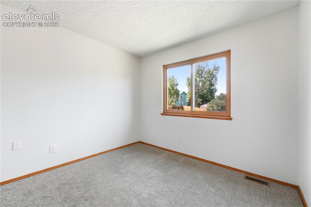 Image 26 of 47: Wall-to-wall carpeting in a neutral tone, white painted walls, and faux woo