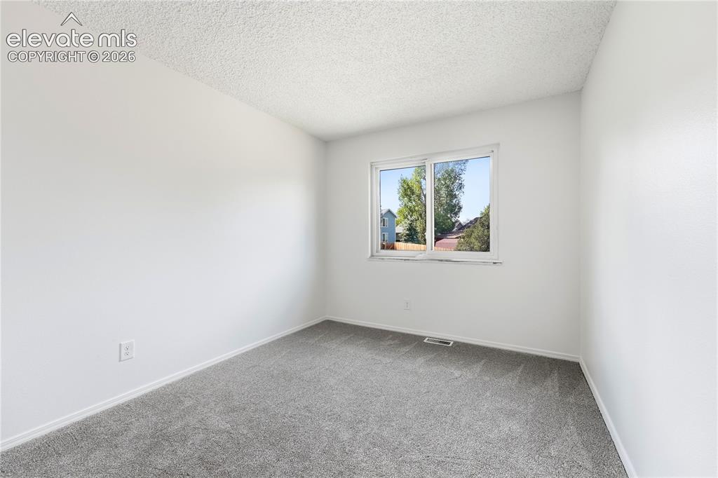 Image 28 of 47: Light grey carpeting, white wall paint, and a window with white trim