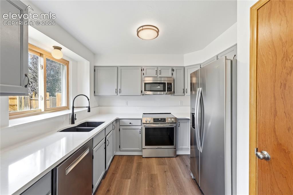 Image 3 of 47: Kitchen featuring gray cabinetry, stone quartz countertops, stainless steel