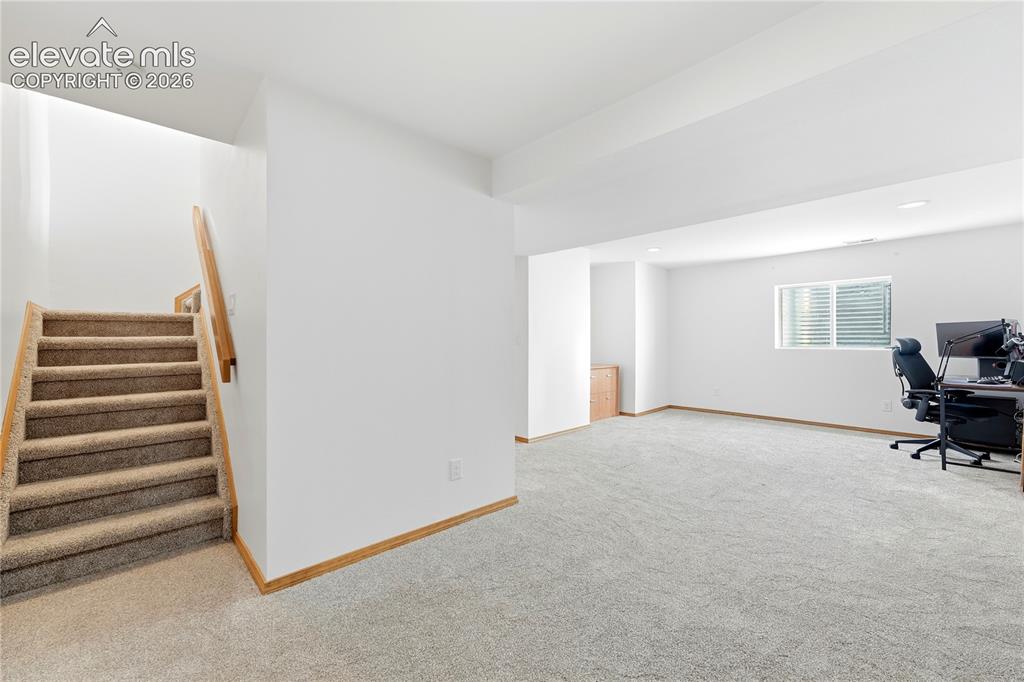 Image 31 of 47: Spacious room featuring light-colored carpeting, white walls, and a window