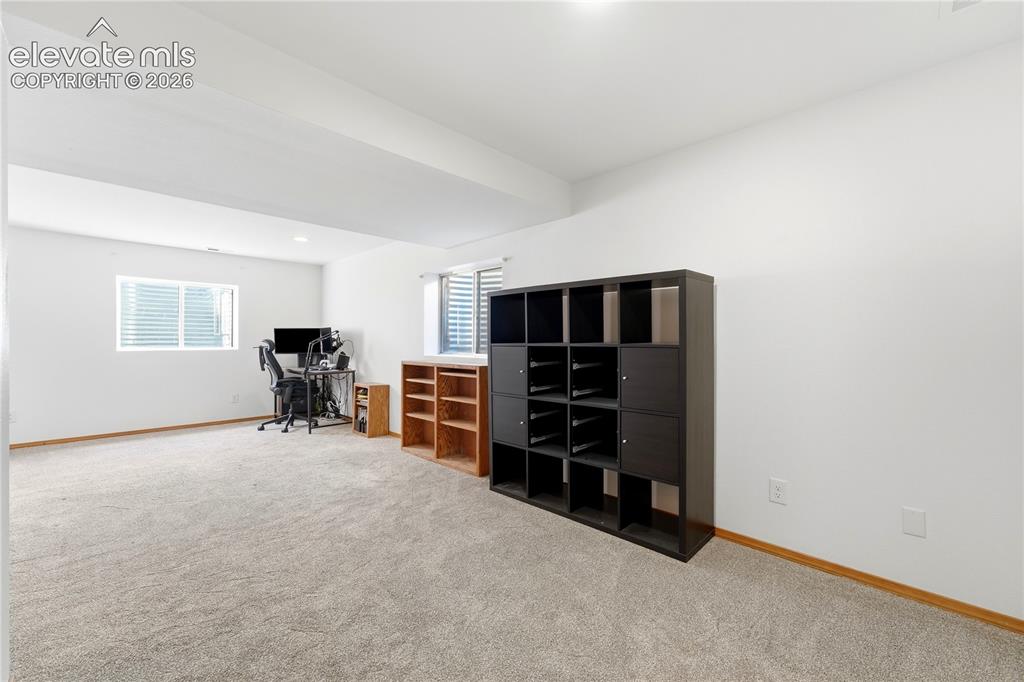 Image 32 of 47: Spacious room featuring light-colored carpeting, white walls, and a window 