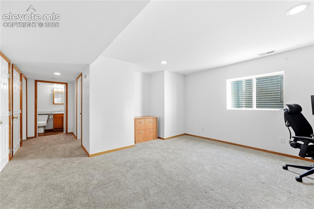 Image 35 of 47: Spacious room featuring light-colored carpeting, white walls, recessed ligh