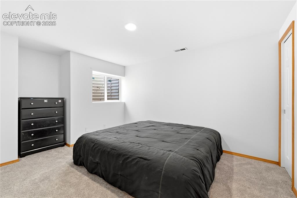 Image 37 of 47: Spacious room featuring light-colored carpeting, white walls, and a window 