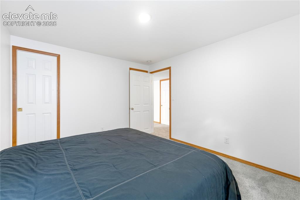 Image 38 of 47: Spacious room featuring light-colored carpeting, white walls, and a window 