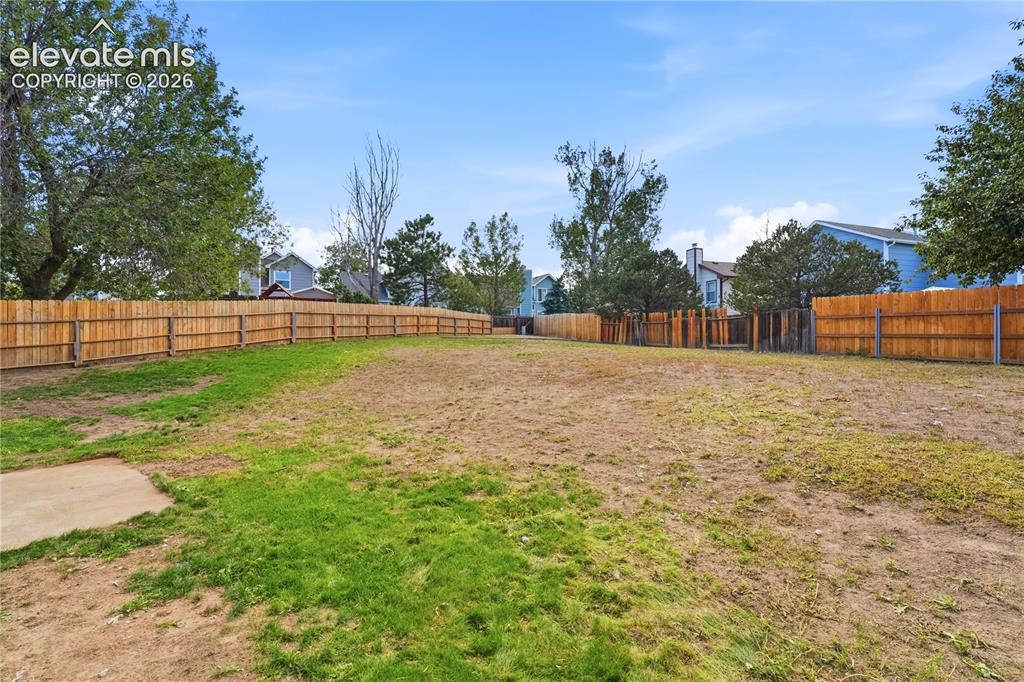 Image 39 of 47: Expansive outdoor space featuring a perimeter wood fence and a concrete pad