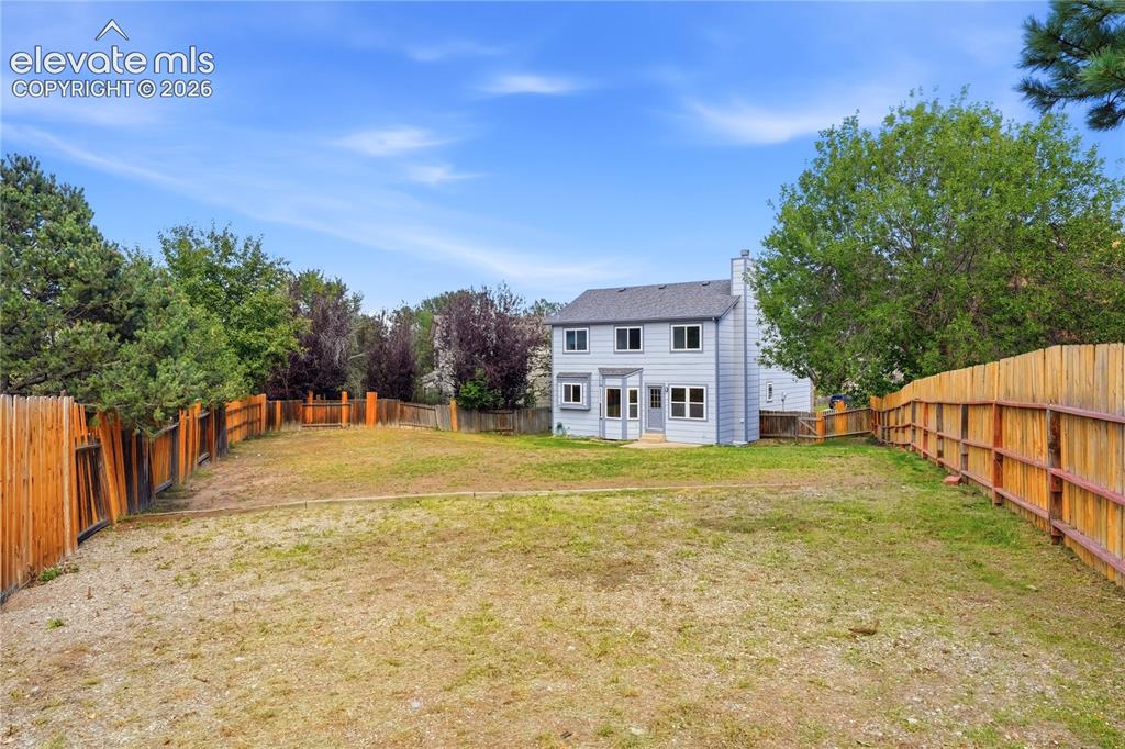 Image 41 of 47: Expansive backyard with a full perimeter wood fence, and a light-colored tw