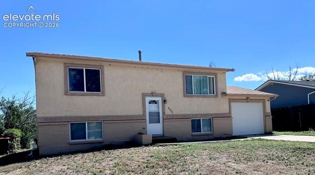 Caption: Split-level home featuring a stucco exterior