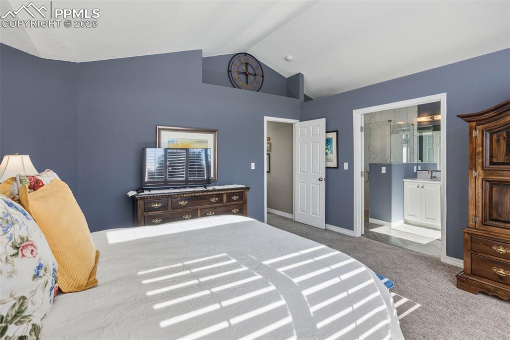 Image 25 of 43: Bedroom with carpet floors and vaulted ceiling