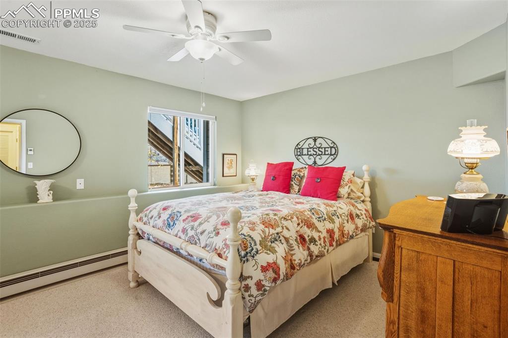 Image 35 of 43: Bedroom featuring a baseboard heating unit, carpet floors, and a ceiling fa