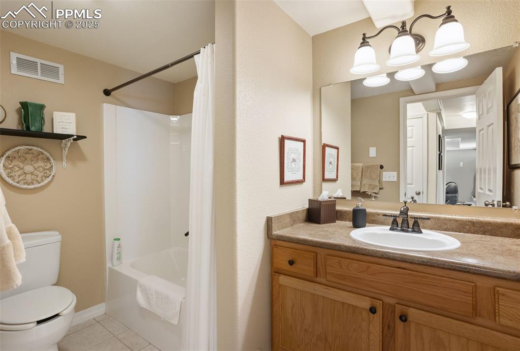 Image 36 of 43: Bathroom featuring light tile patterned floors, shower / tub combo, and van