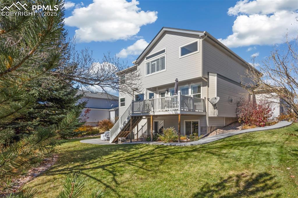 Image 42 of 43: Rear view of house featuring a deck, a yard, and stairway