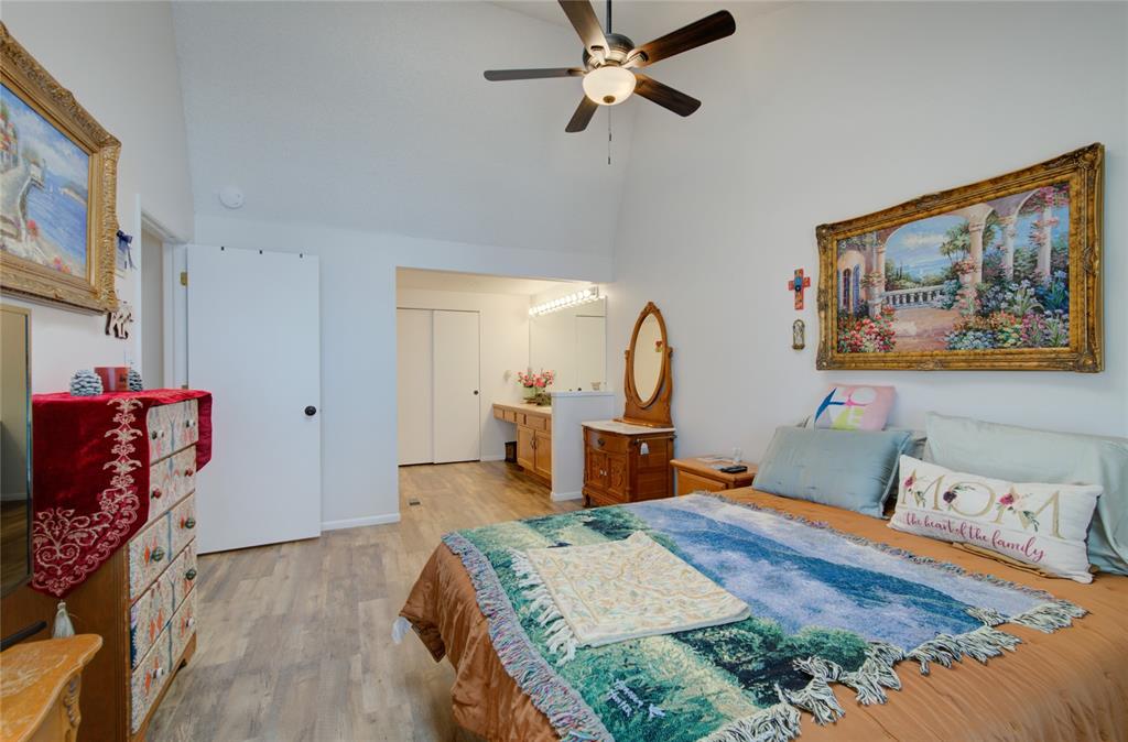 Image 14 of 21: Vaulted ceiling bedroom featuring wood-finish flooring, a ceiling fan, and 