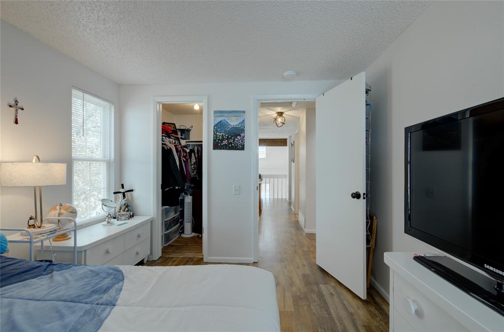 Image 19 of 21: Light-filled room featuring a single window with blinds, wood-finish floori